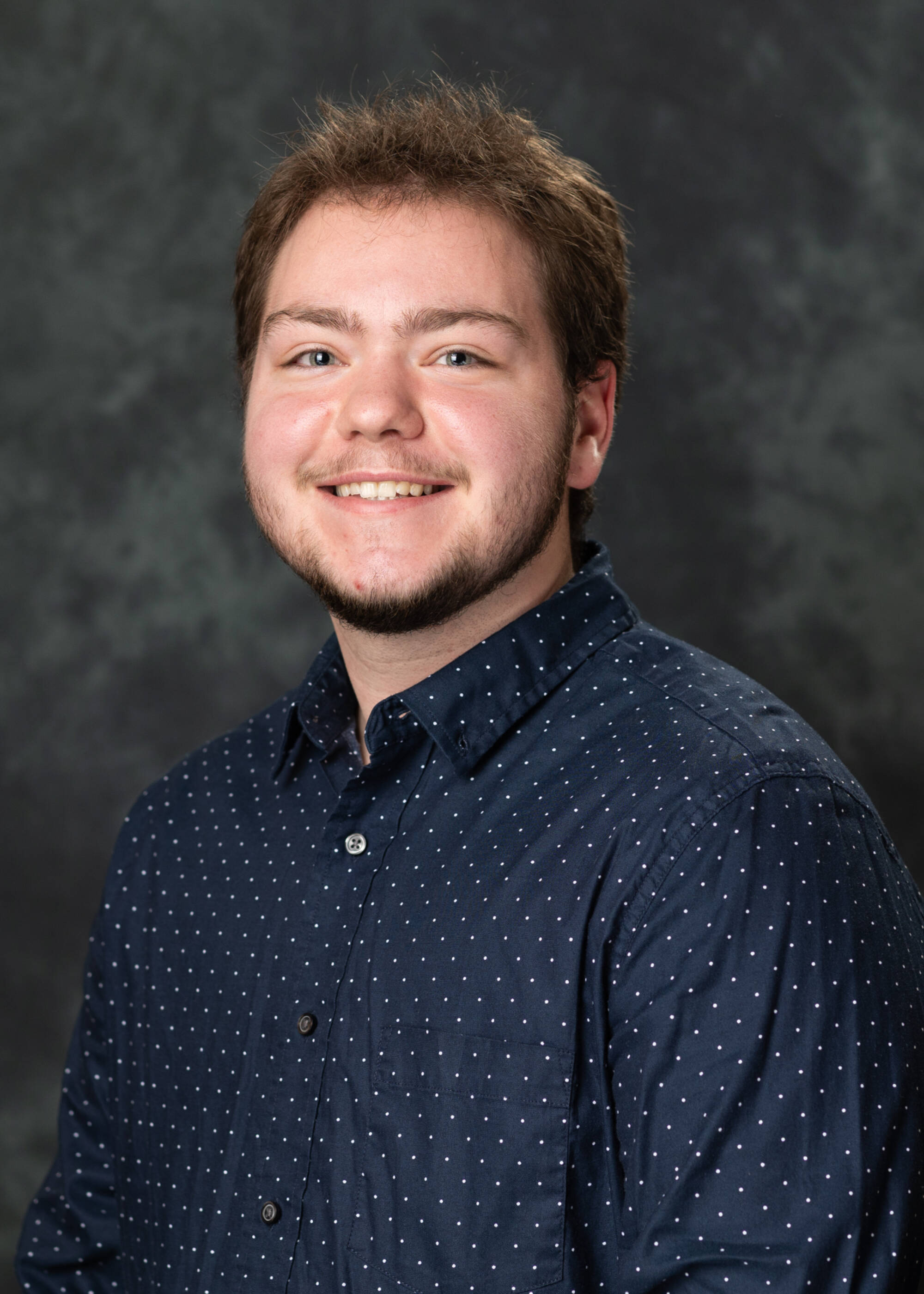 Grayson Rodgers smiling in a black dress shirt